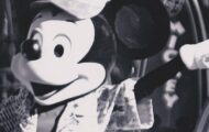 Schwarzweißaufnahme von Micky Maus mit erhobenem Arm und Zylinder