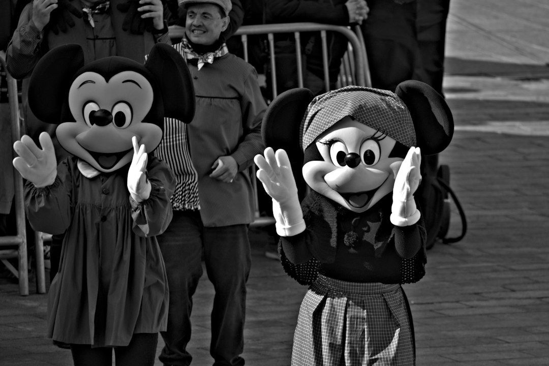 Mickey und Minnie winken vor Zuschauern in historischen Kostümen